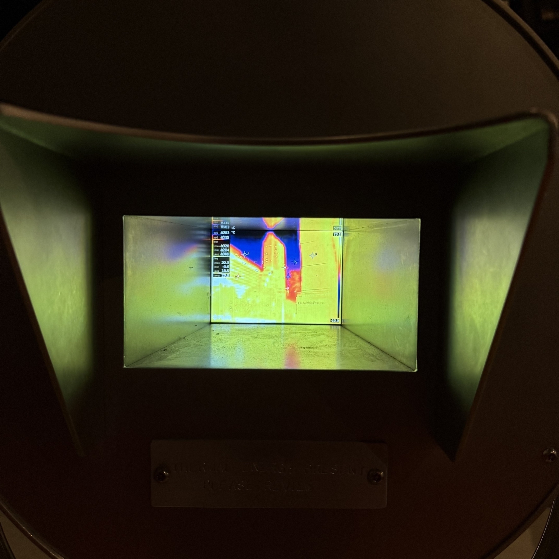 A thermal camera display shows a heat map indicating temperature variations in a scene.
